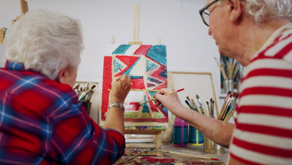 Senior couple painting together in an artist atelier.