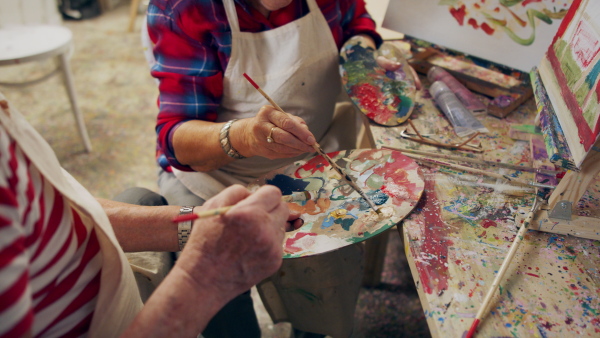 Senior couple painting together in an artist atelier.