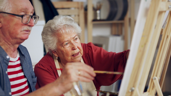 Senior couple painting together in an artist atelier.