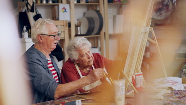 Senior couple painting together in an artist atelier.