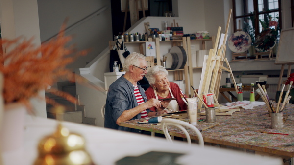 Senior couple painting together in an artist atelier.