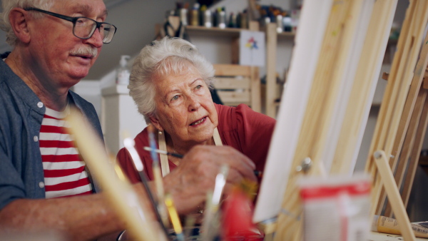 Senior couple painting together in an artist atelier.