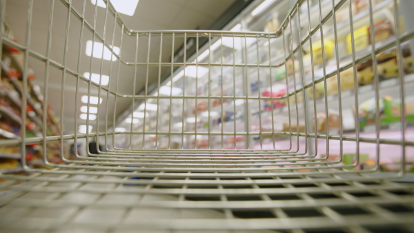 A view from empty trolley in supermarket, Inflation and economic recession concept.