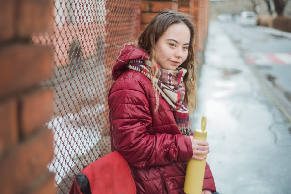 A happy young woman with Down syndrome resting in town in winter