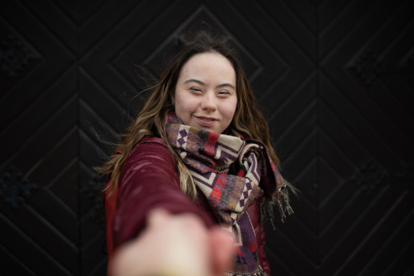 A young woman with Down syndrome looking at camera on black background