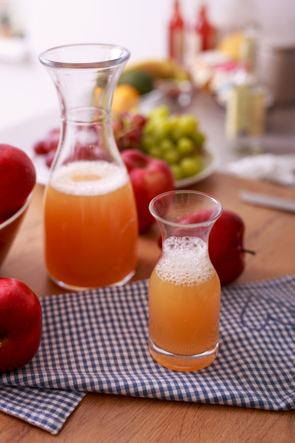 Fresh detox juice from fruit in glass bottles on a kitchen counter