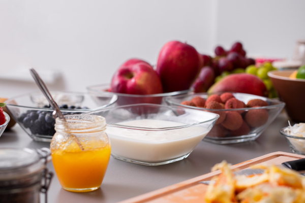 Yogurt in a glass bowl with healthy breakfast on table.