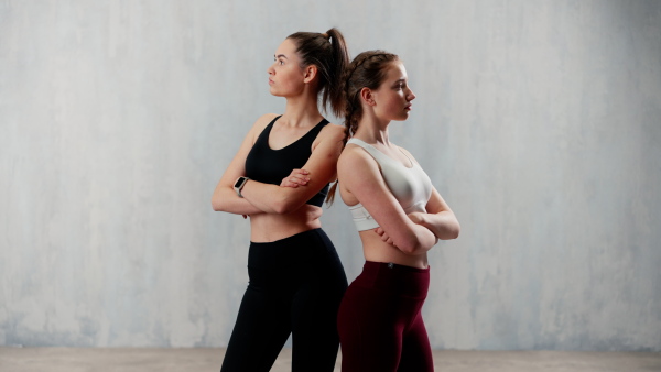 Young beautiful athlete women are posing in a studio, copy space.