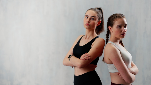 Young beautiful athlete women are posing in a studio, copy space.