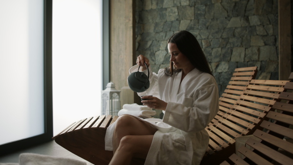 A mature woman enjoying her vacation in spa resort, drinking coffe and looking at camera.