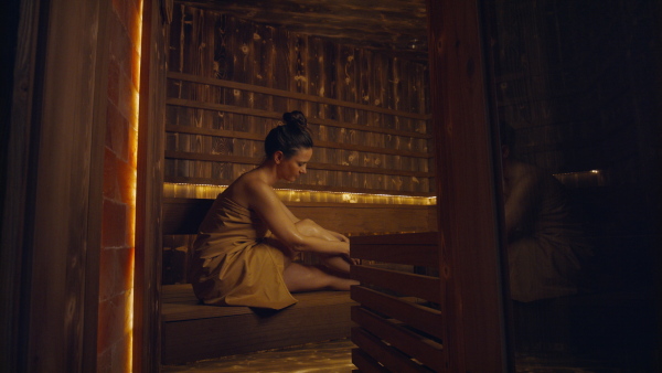 A mature woman enjoying her vacation in spa resort, sitting in sauna and looking at camera.