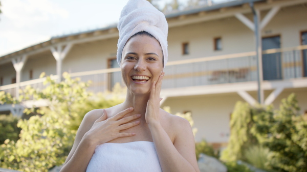 A mature woman enjoying her vacation in spa resort, standing on terrace and looking at camera.