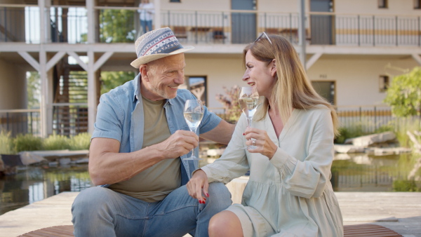 A senior couple enjoying their vacation in spa resort, sitting on terrace and looking at camera.