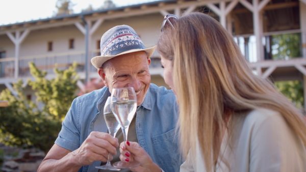 A senior couple enjoying their vacation in spa resort, sitting on terrace and looking at camera.