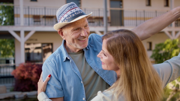 A senior couple enjoying their vacation in spa resort, dancing on terrace.