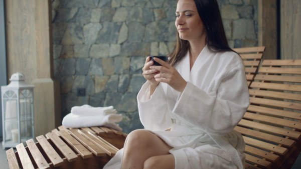 A mature woman enjoying her vacation in spa resort, drinking coffe and looking at camera.