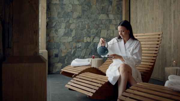 A mature woman enjoying her vacation in spa resort, drinking coffe and looking at camera.