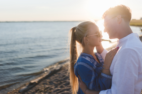 Young cupple cuddling during sunset at lake.