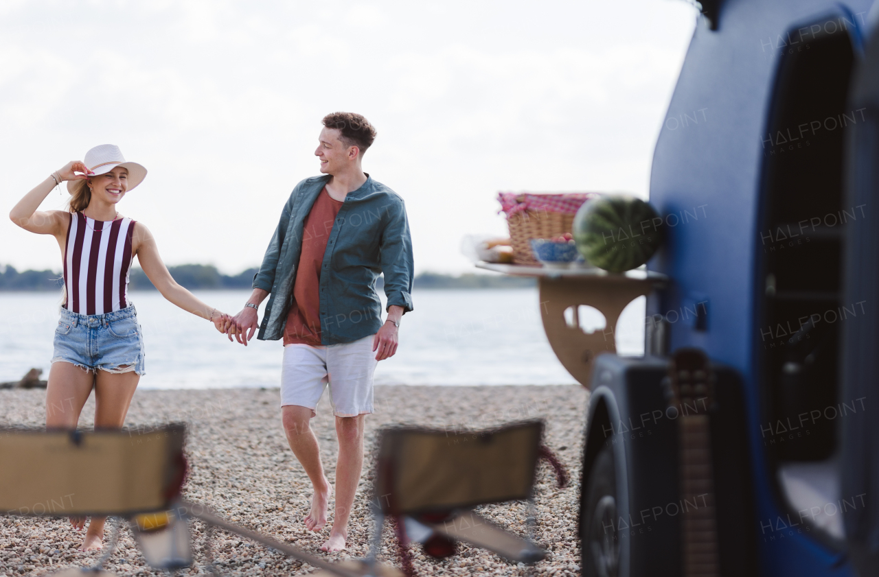 Young couple in front of van during summer holiday.