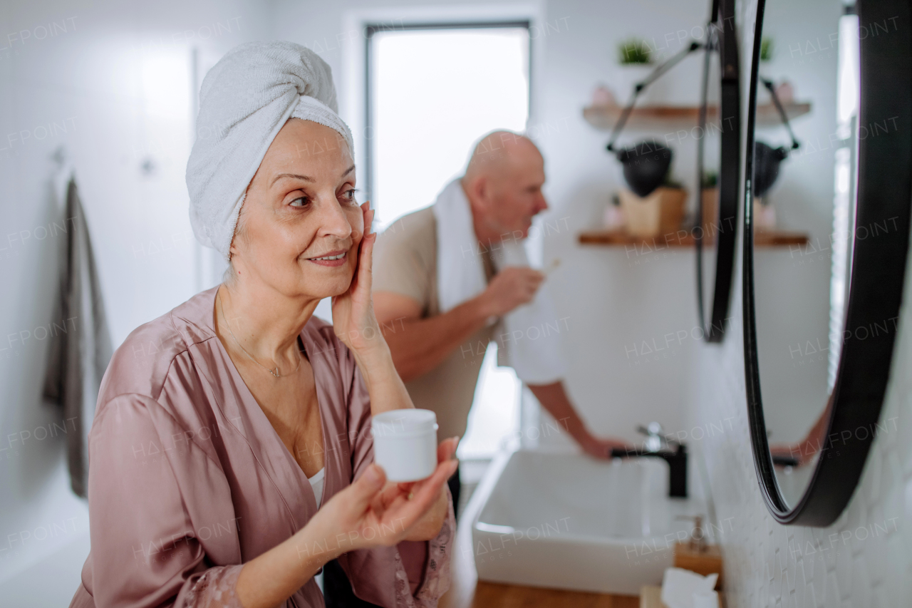 A senior couple in bathroom, brushing teeth and washing, morning routine concept.