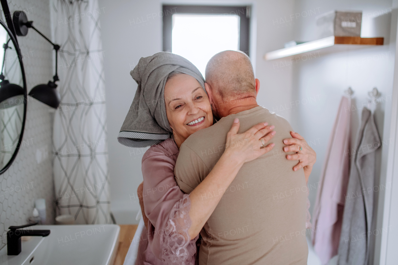 A senior couple in bathroom, hugging and smiling, morning routine concept.