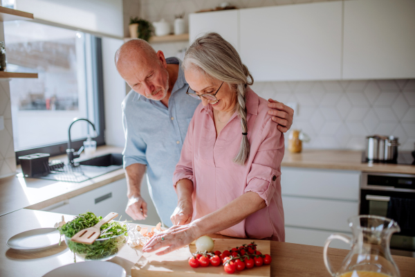 A senior couple cooking together at home.