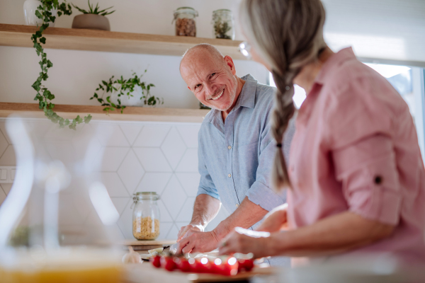 A senior couple cooking together at home.