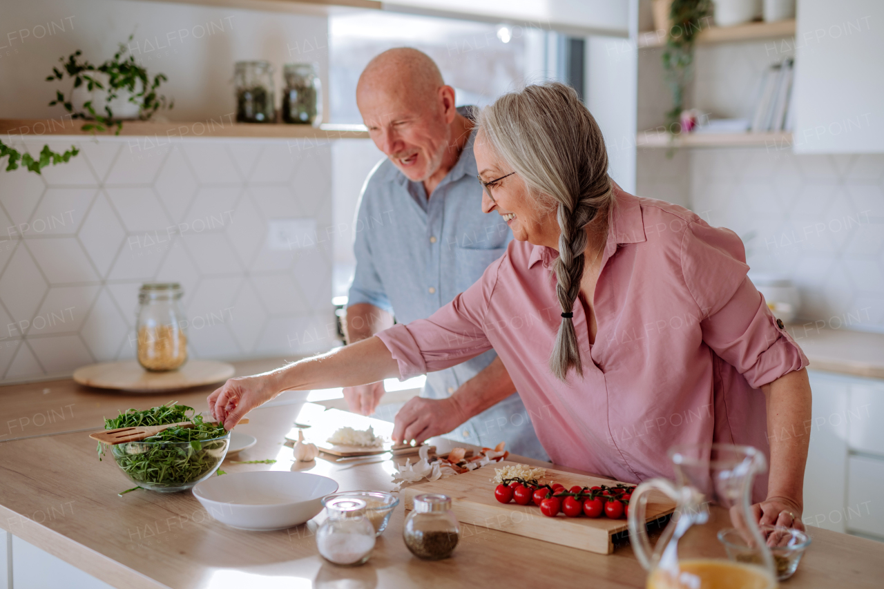 A senior couple cooking together at home.