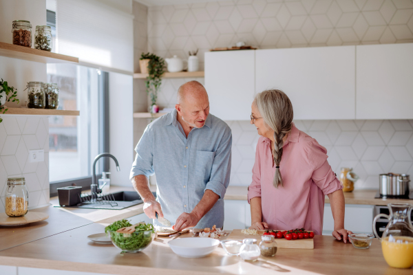 A senior couple cooking together at home.