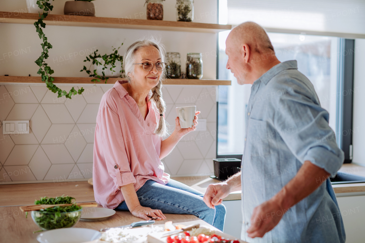 A senior couple cooking together at home.