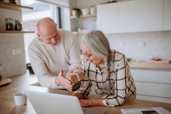 A happy senior woman getting present from her husband.