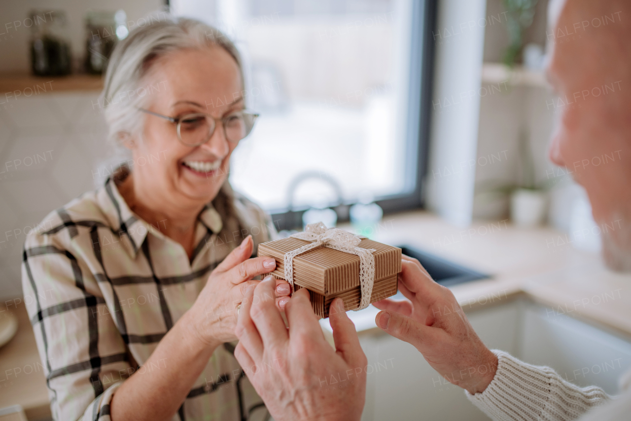 A happy senior woman getting present from her husband.