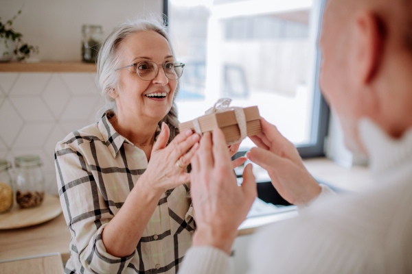 A happy senior woman getting present from her husband.