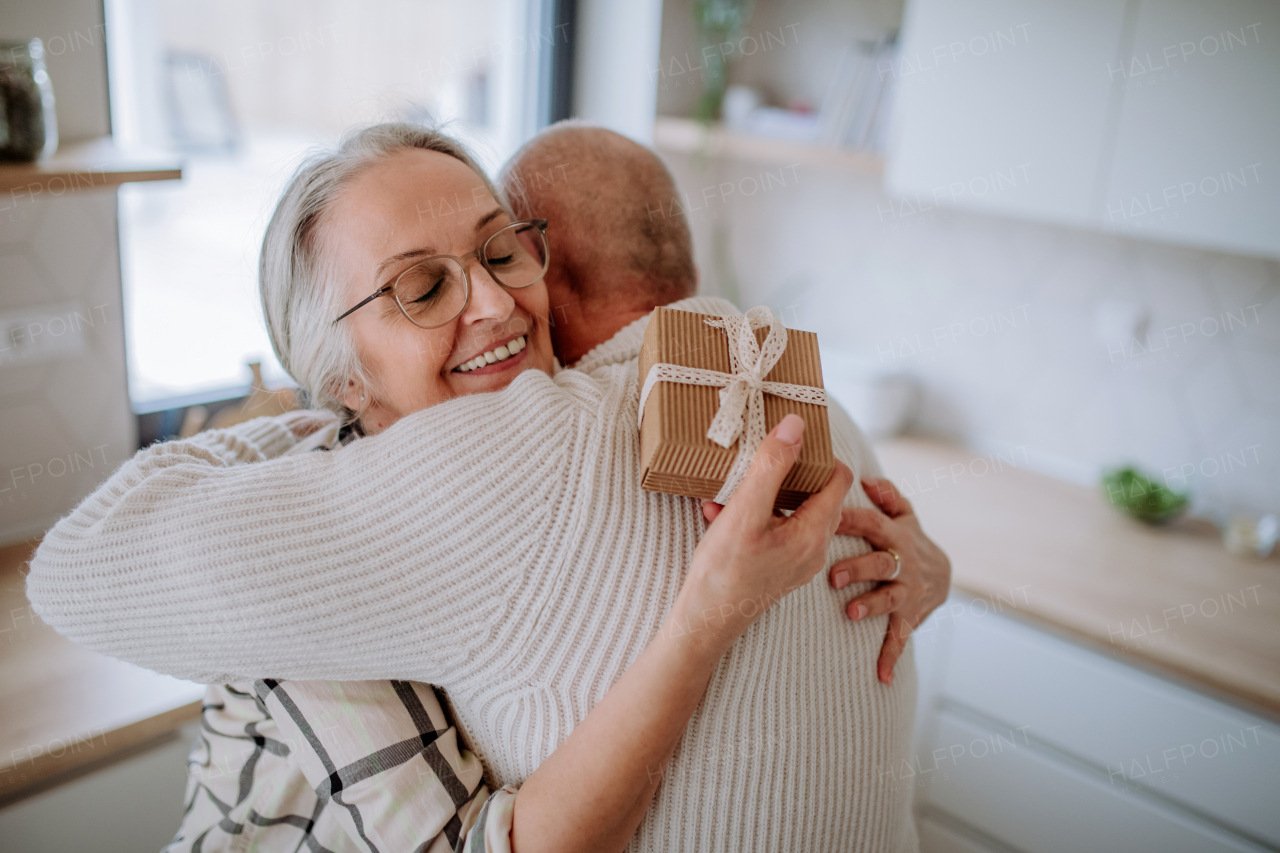 A happy senior woman getting present from her husband.