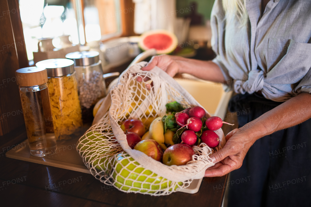 A close up of unrecognizable senior woman unpacking shopping indoors at home, sustainable lifestyle.