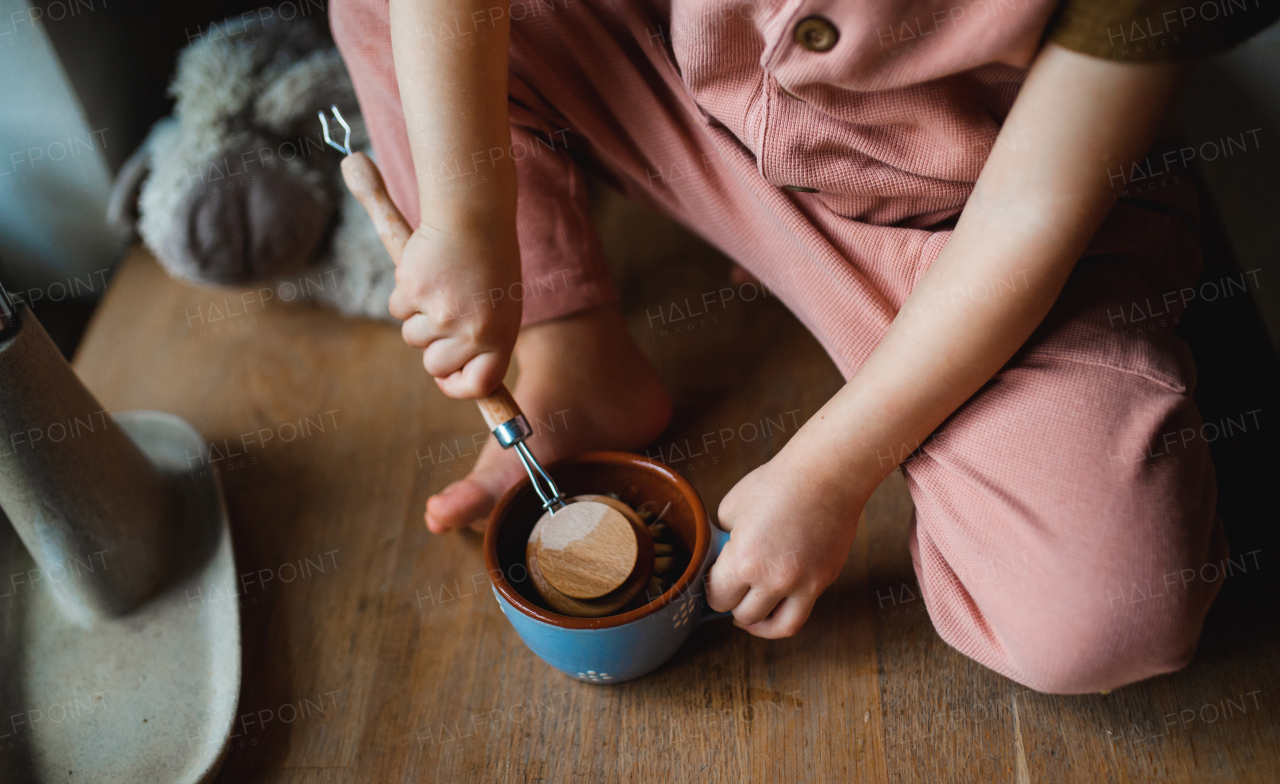 A top view of unrecognizable small child washing dishes indoors at home, daily chores concept.