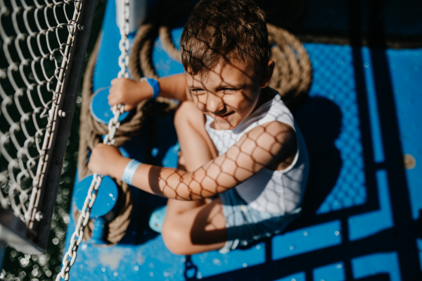 A little curious boy looking at water from motor boat.