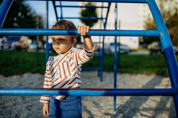 A little boy playing on an outdoor playground.