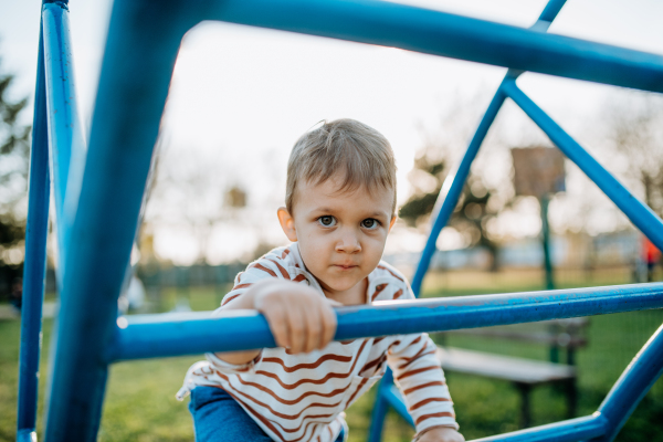 A little boy playing on an outdoor playground.