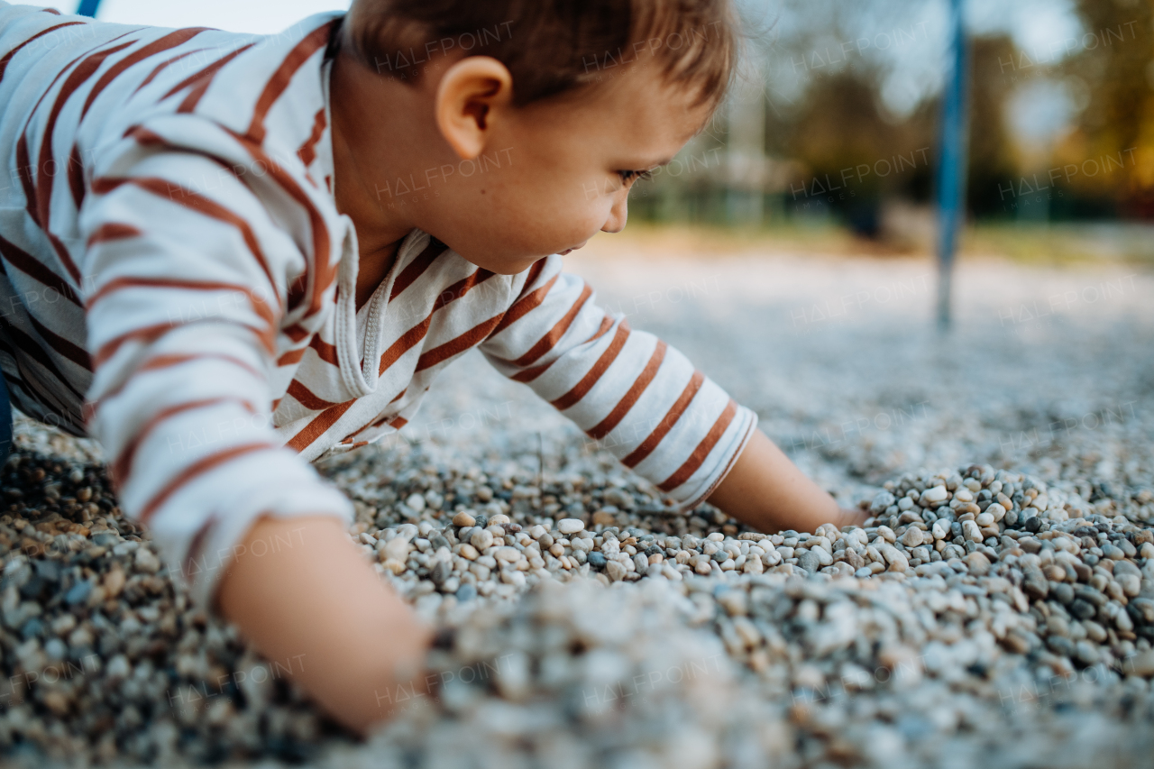 A little boy playing on an outdoor playground.