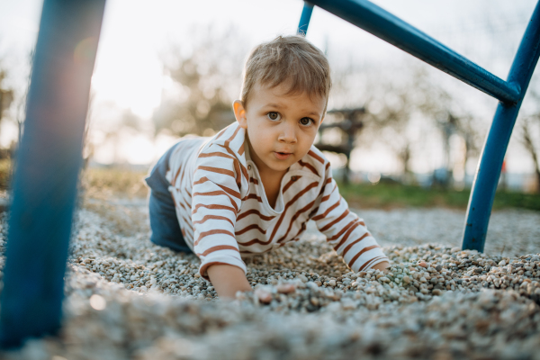 A little boy playing on an outdoor playground.