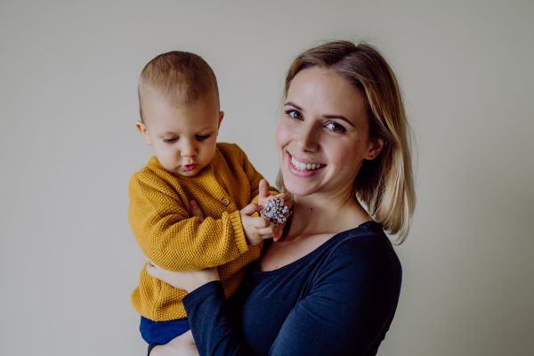 A happy young mother with little son looking at camera.