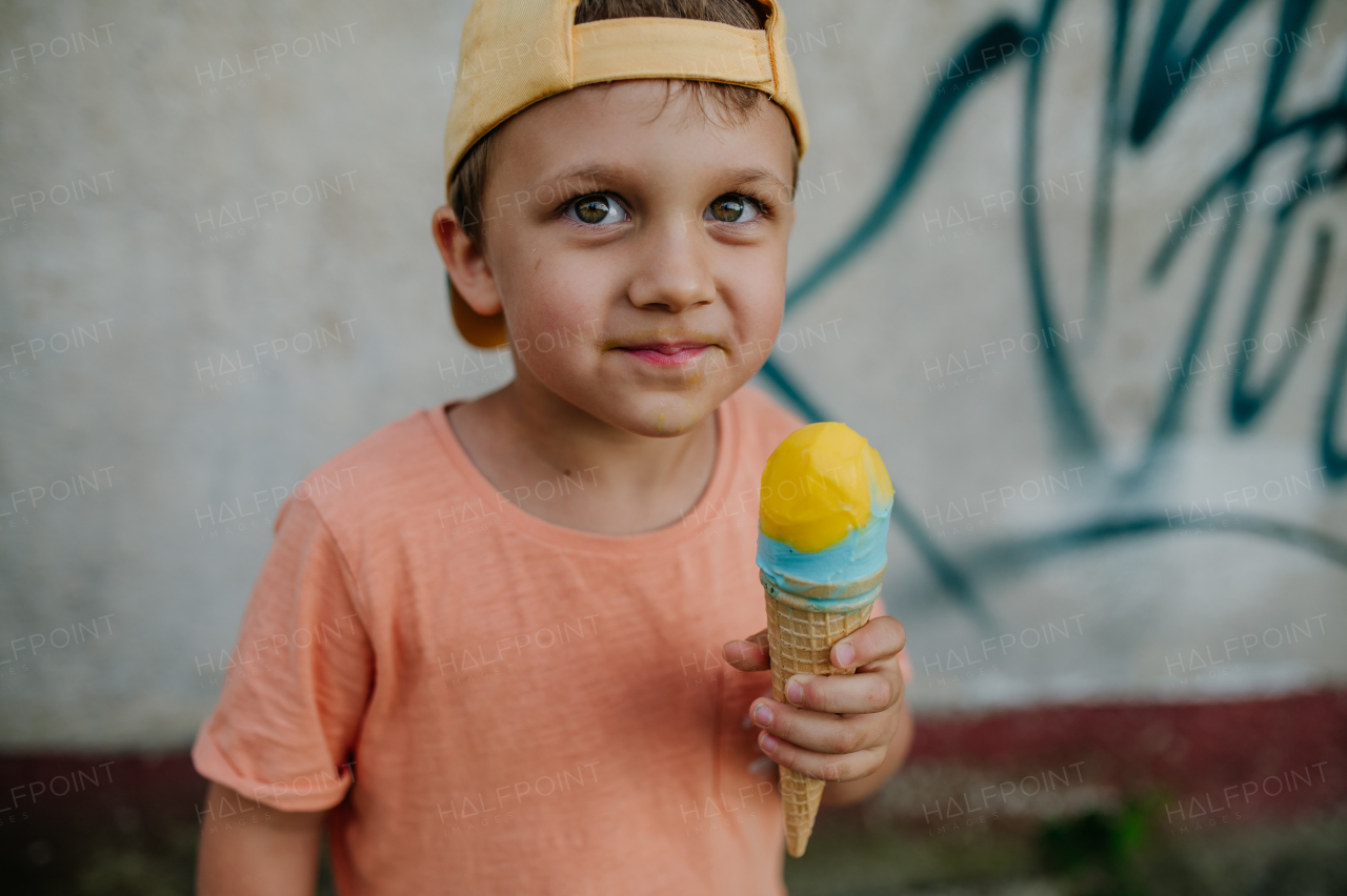 A little cute boy with ice cream outdoors in summer