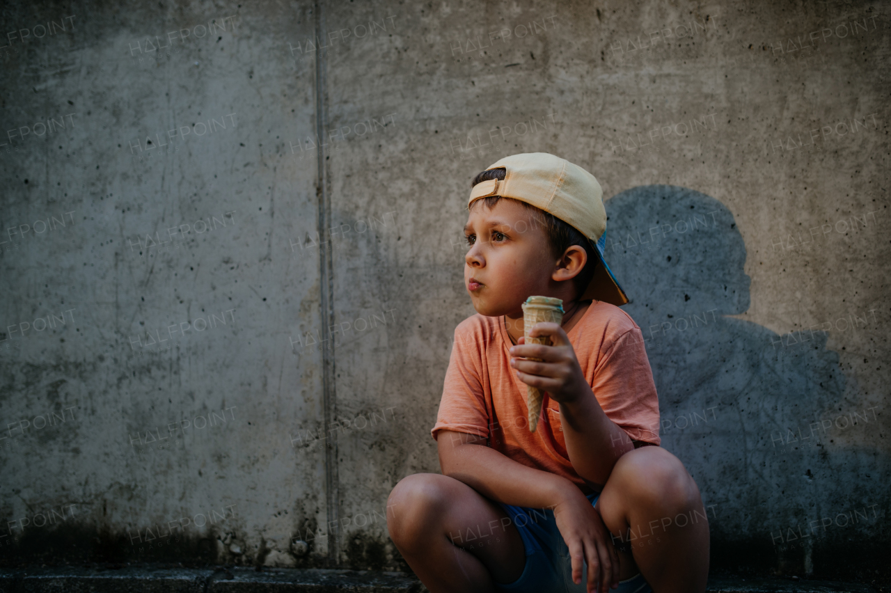 A little cute boy with ice cream outdoors in summer