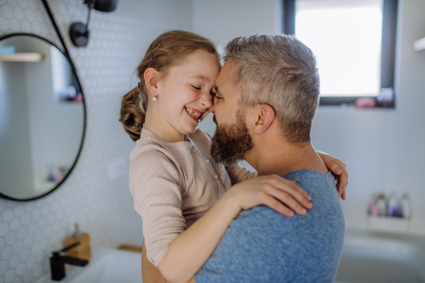 A father kissing his little daughter in bathroom.