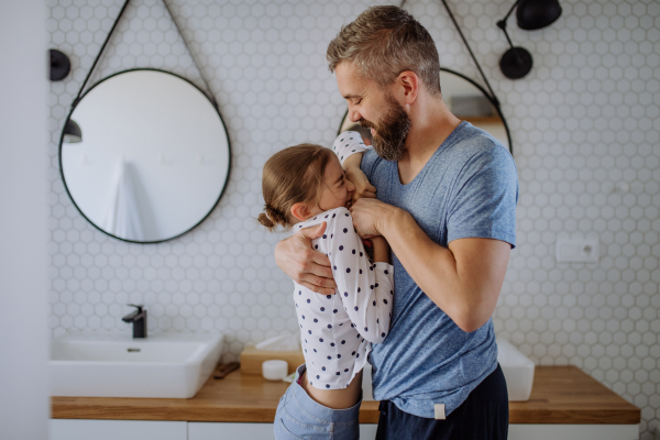 A father having fun with his little daughter in bathroom.