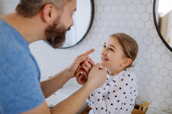 A father having fun with his little daughter in bathroom.