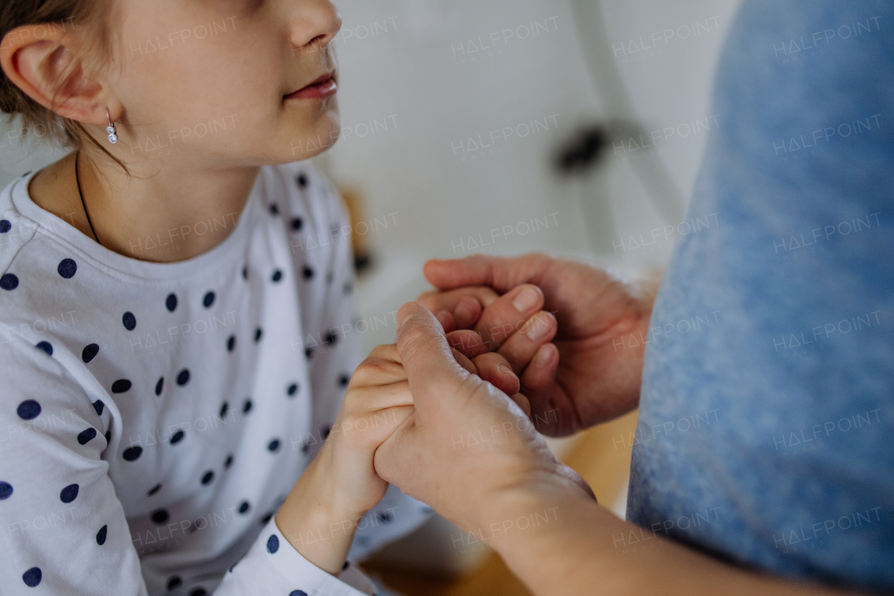 A close-up of father holding his little daughter's hands.