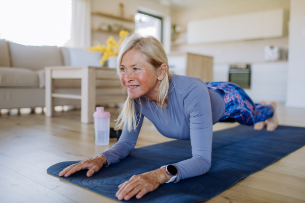 A fit senior woman doing workout exercise at home, active lifestyle concept.