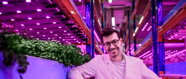 Portrait of worker looking at camera on aquaponic farm, sustainable business and artificial lighting.